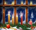Christmas candles lit in front of a window